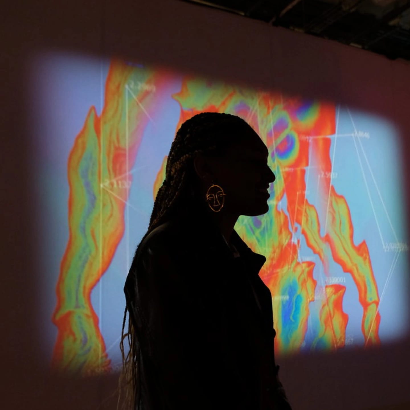 Alisha Gondalia silhouetted against a projected thermal render