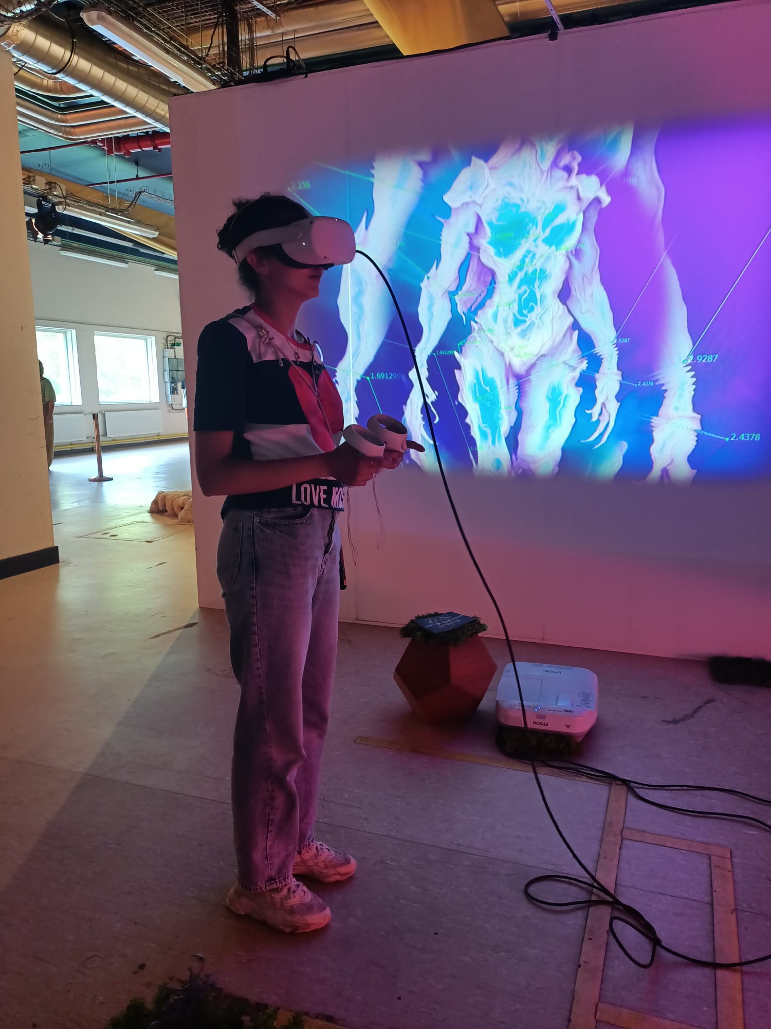 Visitor wearing a VR headset in front of the thermal projection wall
